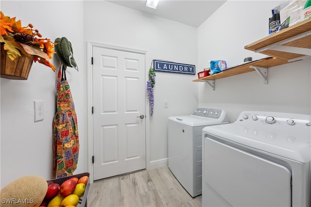 washroom with light hardwood / wood-style floors and washing machine and clothes dryer