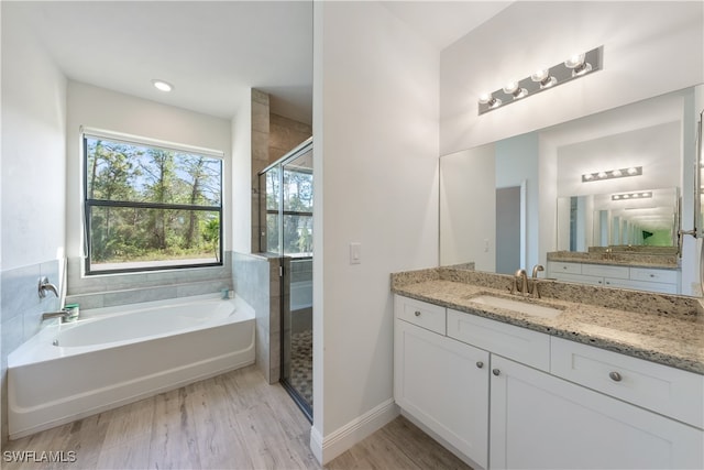 bathroom featuring hardwood / wood-style flooring, vanity, and shower with separate bathtub