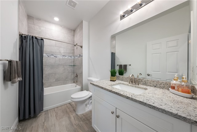 full bathroom featuring toilet, shower / bath combo with shower curtain, vanity, and hardwood / wood-style flooring