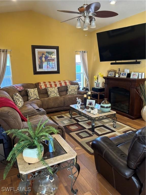 living room featuring light hardwood / wood-style flooring, ceiling fan, and lofted ceiling