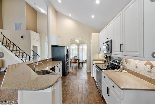 kitchen with high vaulted ceiling, sink, dark hardwood / wood-style floors, appliances with stainless steel finishes, and white cabinetry