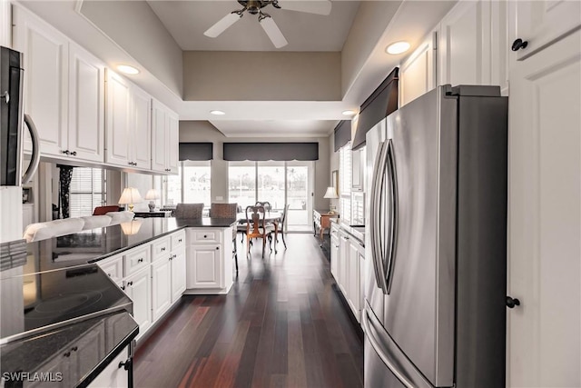 kitchen featuring dark wood-type flooring, white cabinets, ceiling fan, kitchen peninsula, and stainless steel refrigerator