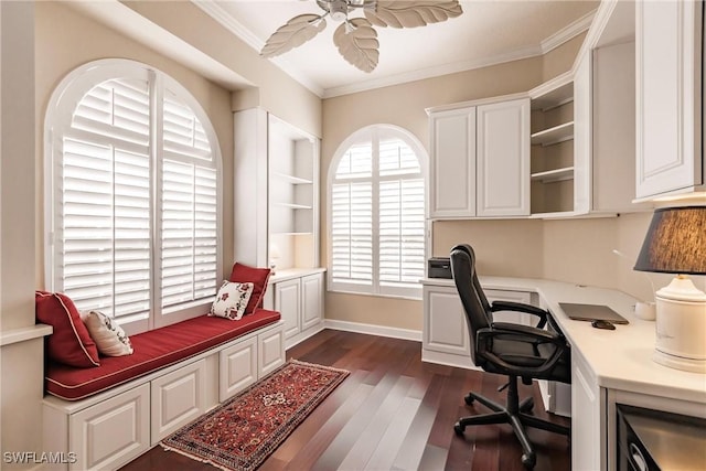 office space featuring crown molding, ceiling fan, dark wood-type flooring, and built in desk