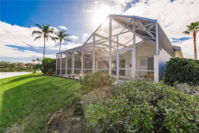 view of home's exterior featuring a lanai, a yard, and a water view