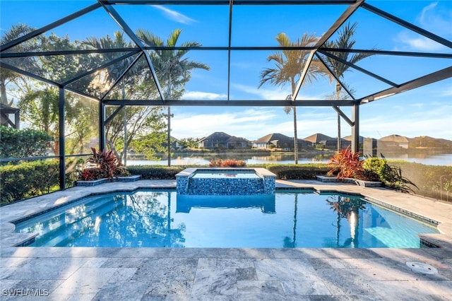 view of pool with glass enclosure, a patio area, a water view, and an in ground hot tub