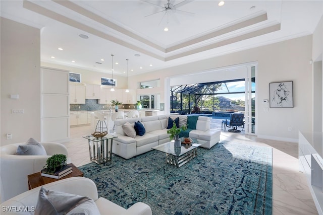 living room with a raised ceiling, ceiling fan, and crown molding