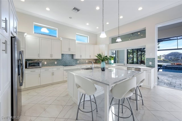 kitchen featuring light stone countertops, sink, white cabinetry, stainless steel appliances, and tasteful backsplash