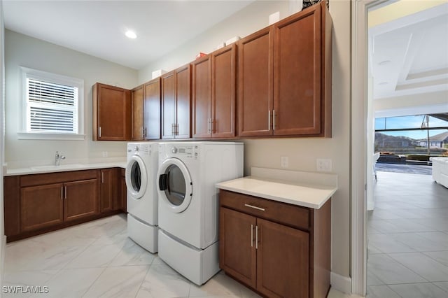 laundry room with cabinets, separate washer and dryer, sink, and a wealth of natural light