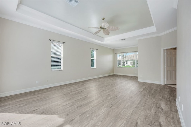 spare room featuring light hardwood / wood-style floors, a raised ceiling, ceiling fan, and crown molding