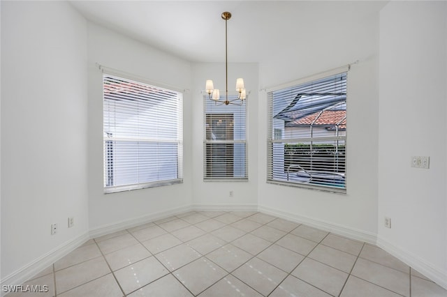 unfurnished dining area with light tile patterned floors and a chandelier