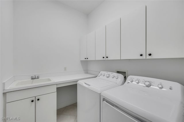 laundry room with cabinets, tile patterned floors, washer and dryer, and sink