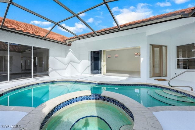 view of pool featuring glass enclosure, an in ground hot tub, and a patio