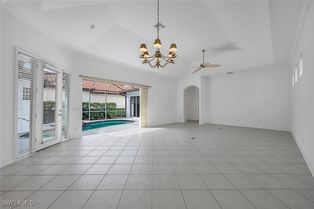 unfurnished living room featuring lofted ceiling, ceiling fan, light tile patterned floors, ornamental molding, and a tray ceiling