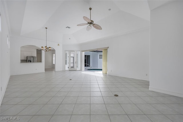 unfurnished living room with light tile patterned floors, ceiling fan with notable chandelier, and high vaulted ceiling