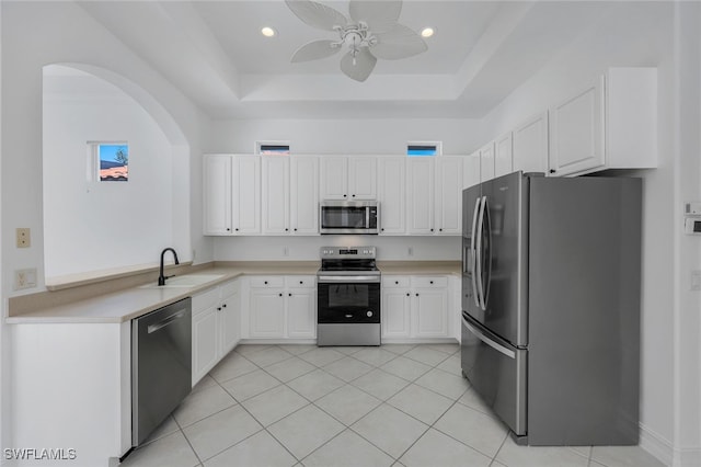 kitchen featuring white cabinets, stainless steel appliances, a raised ceiling, and sink