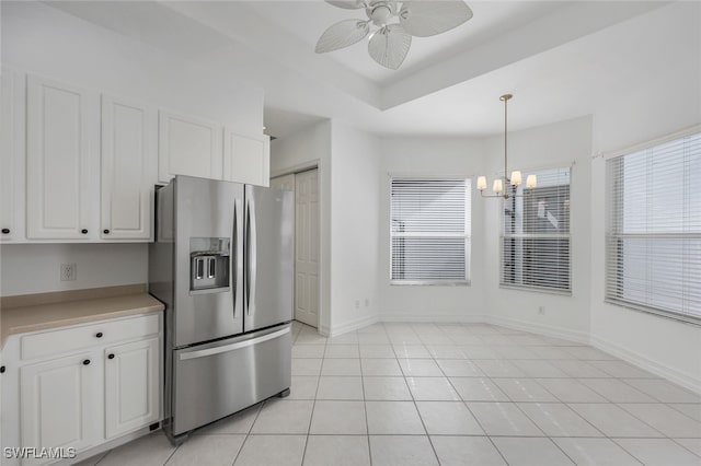 kitchen with a wealth of natural light, stainless steel fridge with ice dispenser, white cabinets, and pendant lighting