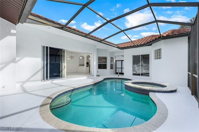 view of swimming pool with an in ground hot tub, a patio area, and a lanai