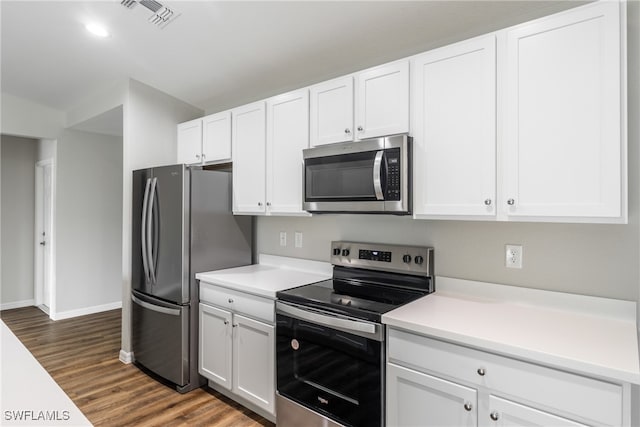 kitchen featuring white cabinets, dark wood-type flooring, and appliances with stainless steel finishes