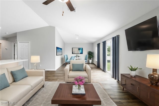 living room featuring ceiling fan, hardwood / wood-style floors, and vaulted ceiling