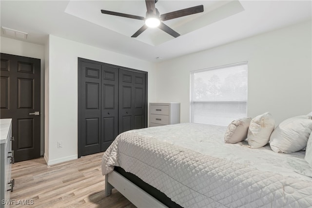 bedroom with ceiling fan, light hardwood / wood-style floors, and a closet