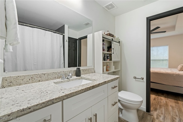 bathroom featuring hardwood / wood-style floors, vanity, toilet, and ceiling fan