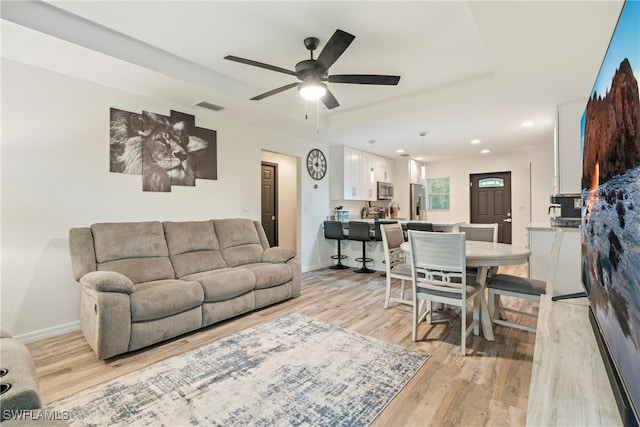 living room featuring ceiling fan and light hardwood / wood-style flooring