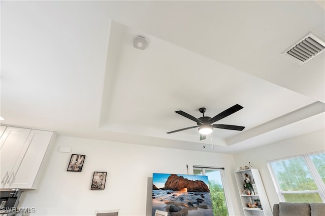 room details featuring a raised ceiling and ceiling fan