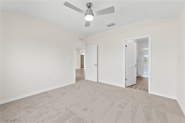 unfurnished bedroom with ceiling fan, lofted ceiling, and light carpet