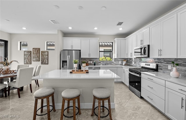 kitchen with white cabinets, a center island, and appliances with stainless steel finishes