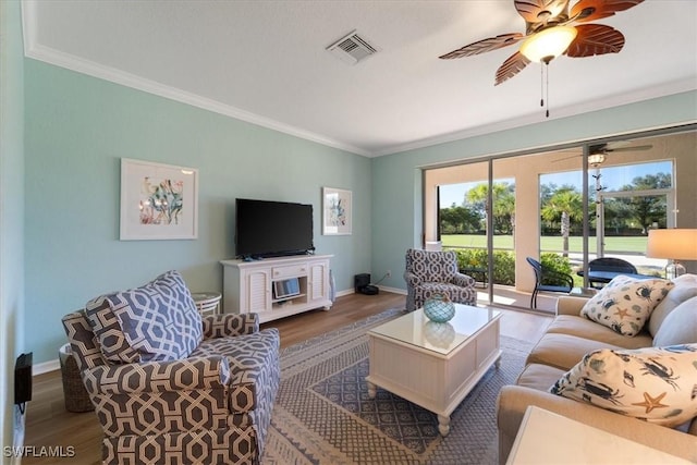 living area featuring visible vents, wood finished floors, and ornamental molding