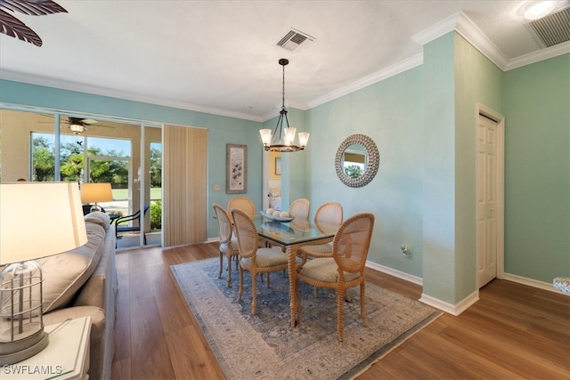 dining room featuring crown molding, hardwood / wood-style floors, and ceiling fan with notable chandelier