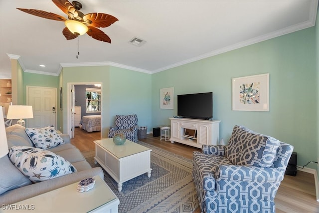 living room featuring ceiling fan, light hardwood / wood-style floors, and ornamental molding