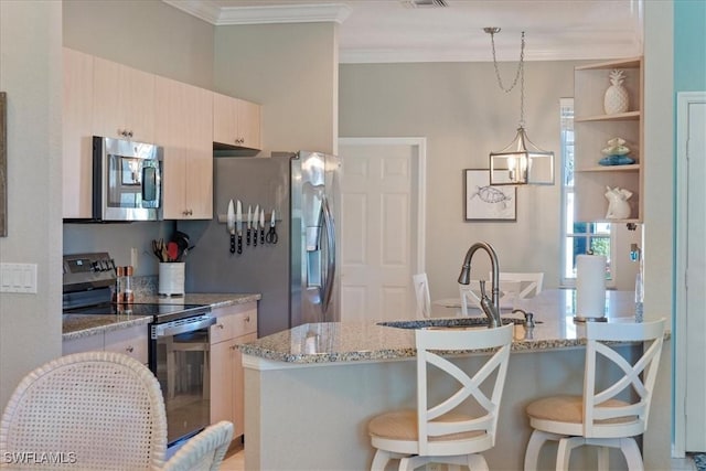 kitchen with a breakfast bar area, stainless steel appliances, a peninsula, a sink, and crown molding