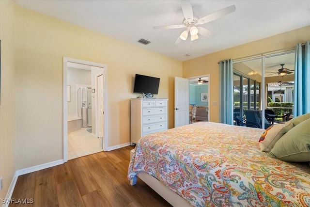 bedroom featuring access to exterior, visible vents, ensuite bath, wood finished floors, and baseboards