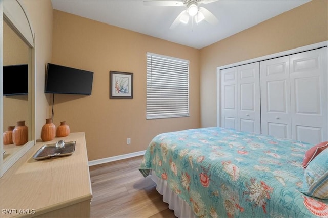 bedroom featuring baseboards, a closet, a ceiling fan, and light wood-style floors