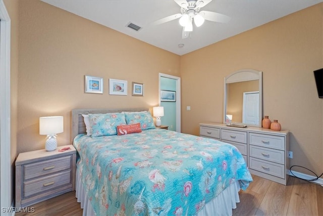 bedroom with ceiling fan, wood finished floors, and visible vents