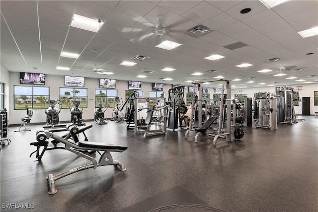 workout area with a paneled ceiling, ceiling fan, and visible vents