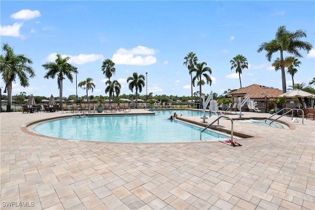 community pool featuring fence and a patio