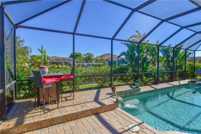 view of swimming pool with pool water feature, glass enclosure, and a patio area