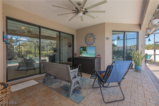 view of patio with glass enclosure and ceiling fan