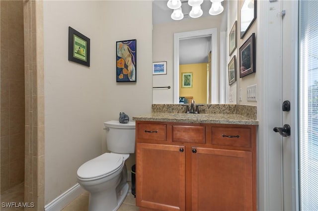 bathroom featuring tile patterned floors, vanity, a tile shower, and toilet