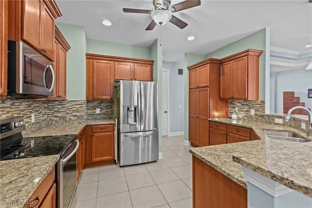 kitchen with decorative backsplash, sink, light stone counters, and stainless steel appliances