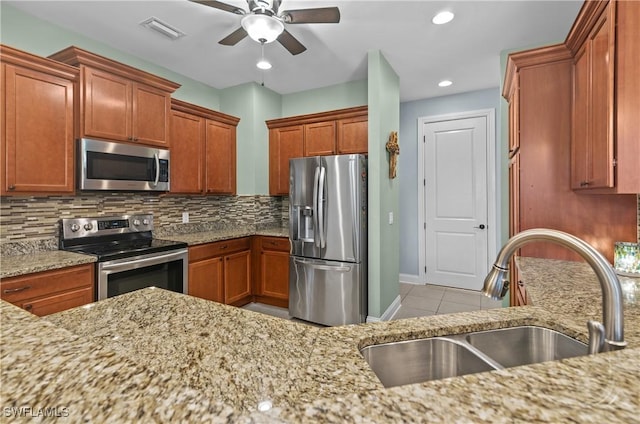 kitchen with ceiling fan, sink, stainless steel appliances, decorative backsplash, and light tile patterned flooring