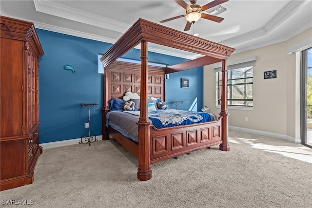 carpeted bedroom featuring a tray ceiling, ceiling fan, and ornamental molding