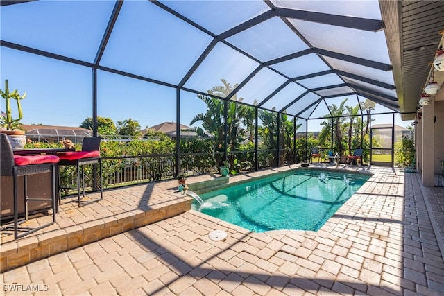 view of pool featuring pool water feature, a patio, and a lanai