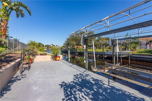 view of patio with a water view and a dock