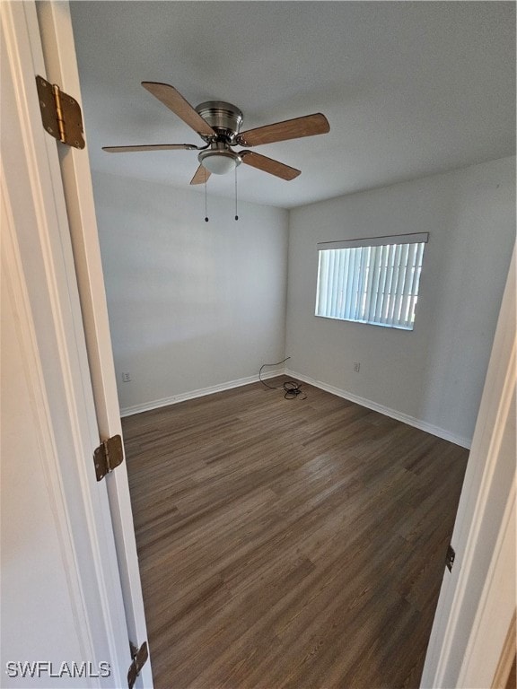 empty room with dark hardwood / wood-style floors and ceiling fan