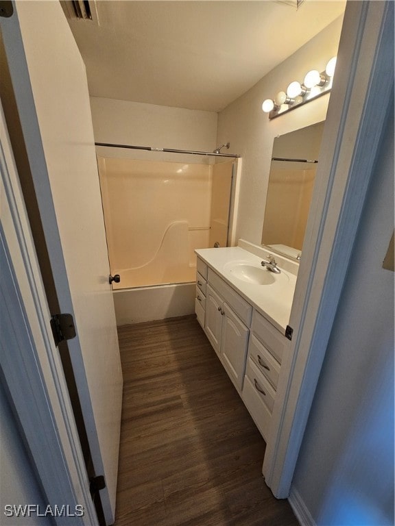 bathroom featuring hardwood / wood-style flooring, vanity, and shower / bath combination