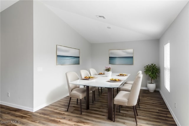 dining room with a wealth of natural light, dark wood-type flooring, and lofted ceiling