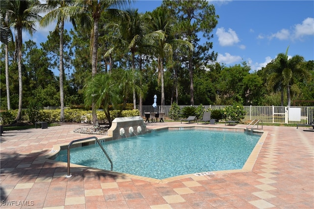 view of swimming pool featuring pool water feature and a patio area